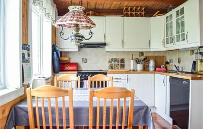 a kitchen with a table with chairs and a chandelier at 6 Bedroom Beautiful Home In Vossestrand in Vossestrand