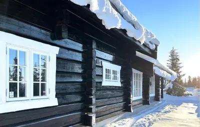a log cabin in the snow with two windows at Cozy Home In Sjusjøen With Sauna in Sjusjøen
