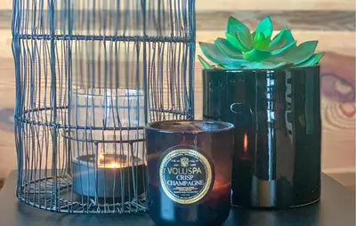 a table with candles and a bird cage with a potted plant at Cozy Home In Sjusjøen With Sauna in Sjusjøen