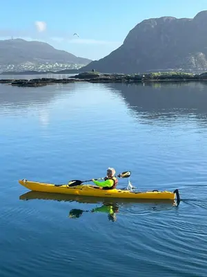 a person in a yellow kayak on a body of water at Torvholmen in Fosnavåg