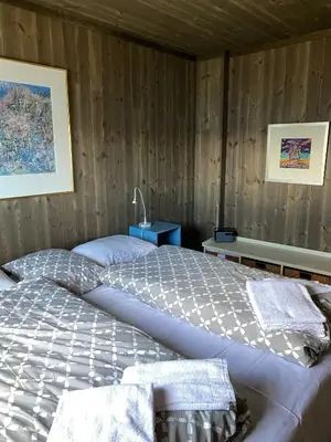 a large bed in a room with wooden walls at Torvholmen in Fosnavåg