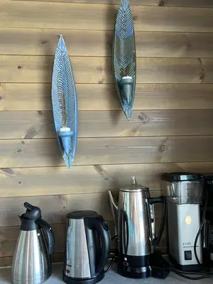 a row of pots and pans hanging on a wall at Torvholmen in Fosnavåg