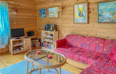 a living room with a red couch and a table at 3 Bedroom Awesome Home In Leikanger in Leikanger