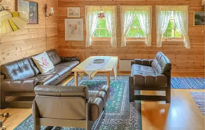 a living room with leather couches and a table at 3 Bedroom Awesome Home In Leikanger in Leikanger