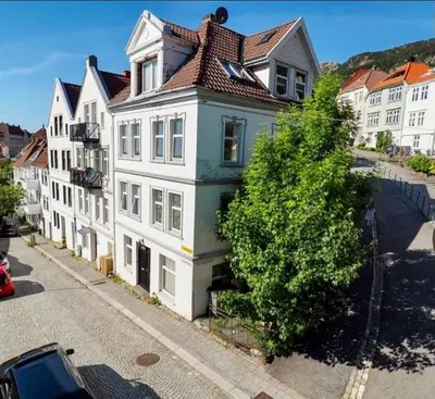 a large white building with a brown roof at Apartment «Ladegården» in Bergen in Bergen