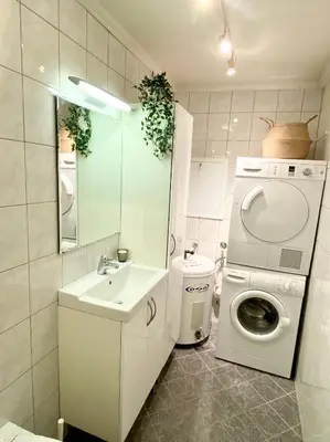 a bathroom with a washing machine and a washer at Apartment «Ladegården» in Bergen in Bergen