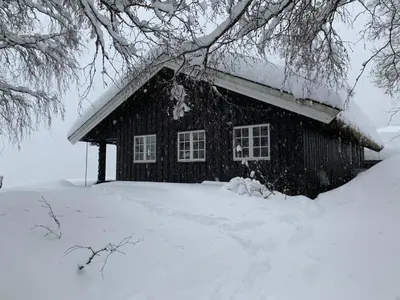 a house covered in snow in front at Kultan in Åmotsdal