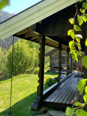a wooden deck with a porch swing at Kultan in Åmotsdal