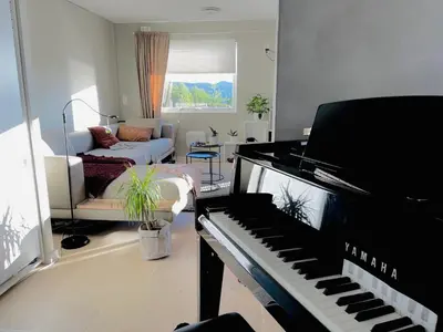 a living room with a piano and a couch at Floien City House -free parking in Bergen
