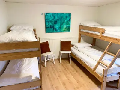 a room with two bunk beds and two chairs at Drømmebrygga in Averoy