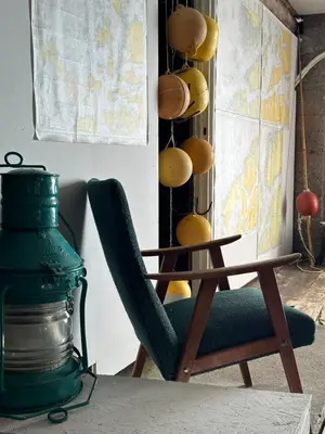 a chair next to a table and a map at Drømmebrygga in Averoy