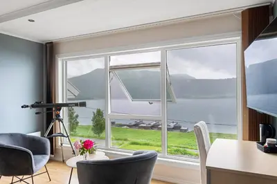 a kitchen with a large window with a view of the water at Moens Motell in Fiskå