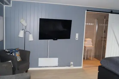 a living room with a television on a blue wall at Moens Motell in Fiskå