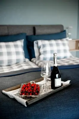 a tray with a bottle of wine and a glass at Moens Motell in Fiskå
