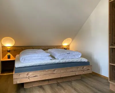 a bed with two pillows on it in a room at Gjestegaarden Leiligheter in Beitostøl