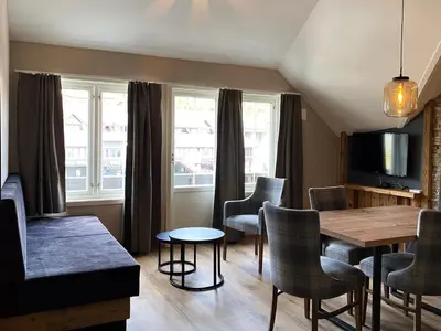 a living room with a dining room table and chairs at Gjestegaarden Leiligheter in Beitostøl