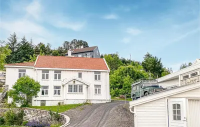 a white house with a truck parked on a road at Cozy Home In Kristiansund With Wifi in Kristiansund