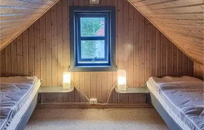 two beds in a room with a window at Cozy Home In Kristiansund With Wifi in Kristiansund