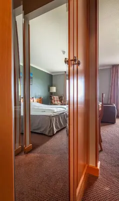 a hotel room with a bed and a open door at Bergo Rom in Beitostøl