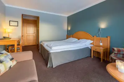 a hotel room with a bed and a couch at Bergo Rom in Beitostøl