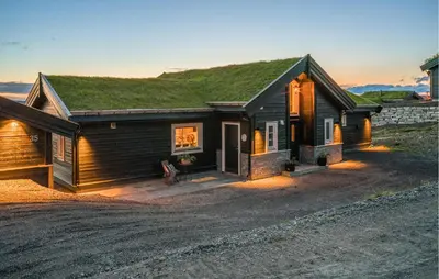 a small house with a grass roof on a dirt road at Nice Home In Øyer With Kitchen in Øyer