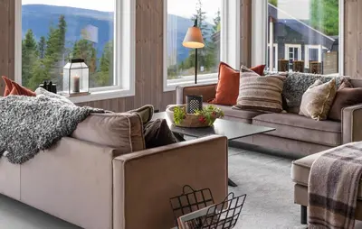 a living room with couches and a table and windows at Nice Home In Øyer With Kitchen in Øyer