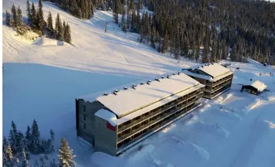 a building covered in snow in the snow at Fin leilighet ca 30 min med bil til Hunderfossen in Favang