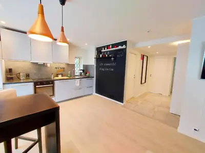 a kitchen with a black refrigerator in a room at Ibsens in Bergen
