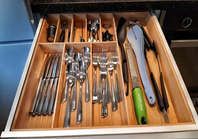 a wooden drawer filled with utensils in a kitchen at Ibsens in Bergen