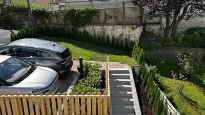 a car parked in a driveway next to a fence at Ibsens in Bergen