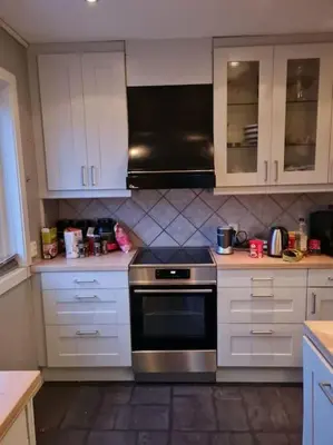 a kitchen with white cabinets and a stove top oven at Beautiful Villa with amazing view in Bergen. in Bergen