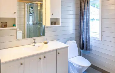 a bathroom with a toilet and a sink at Gorgeous Home In Øydegard in Nastad