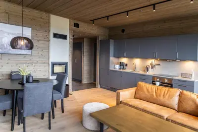 a kitchen and living room with a couch and a table at Mosetertoppen Skiline - Hafjell Ski Resort in Øyer