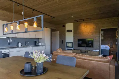 a kitchen and living room with a table and chairs at Mosetertoppen Skiline - Hafjell Ski Resort in Øyer