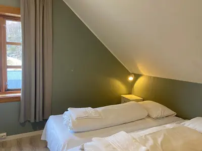 a bedroom with two beds and a green wall at Winjum Hostel Stegastein in Aurland