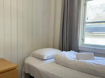 a bed with two pillows sitting next to a window at Winjum Hostel Stegastein in Aurland