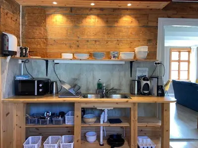 a kitchen with a sink and a wooden wall at Winjum Hostel Stegastein in Aurland
