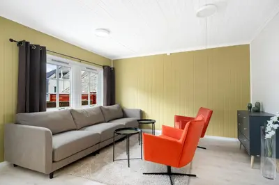 a living room with a couch and two orange chairs at Aurland Guesthouse in Aurland