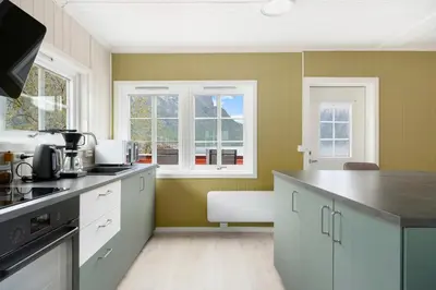 a kitchen with green walls and a counter top at Aurland Guesthouse in Aurland
