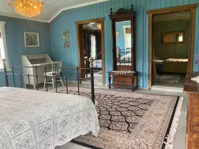 a bedroom with a bed and a blue wall at Steinsvoll Gård in Vang I Valdres