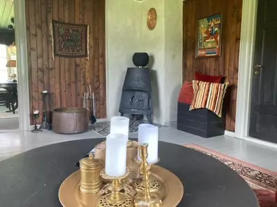 a living room with a table with candles and a stove at Steinsvoll Gård in Vang I Valdres