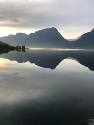 a large body of water with mountains in the background at Steinsvoll Gård in Vang I Valdres