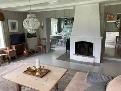 a living room with a fireplace and a table at Steinsvoll Gård in Vang I Valdres