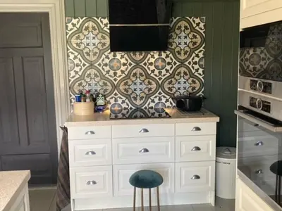 a kitchen with a white dresser and a wall at Steinsvoll Gård in Vang I Valdres