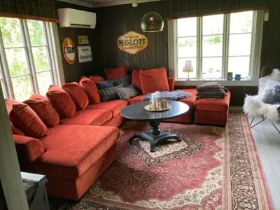 a living room with a red couch and a table at Steinsvoll Gård in Vang I Valdres
