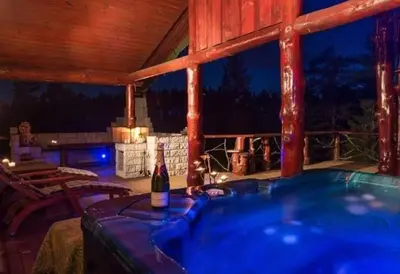 a hot tub on a deck with a bottle of wine at DaVita Ranch in Tranhaug