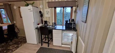 a small kitchen with a refrigerator and a table at DaVita Ranch in Tranhaug