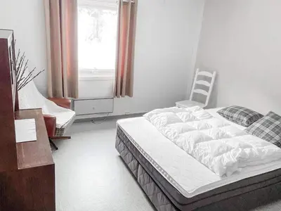 a bedroom with a bed and a chair and a window at 8 person holiday home in Halsanaustan-By Traum in Korsnes