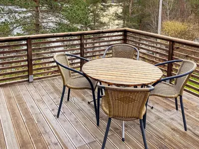 a wooden table and chairs on a deck at 8 person holiday home in Halsanaustan-By Traum in Korsnes
