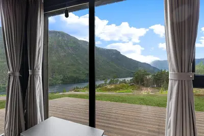 a room with a large window with a view of a mountain at Sogndal Fjordpanorama - Studio Cabins With View in Sogndal